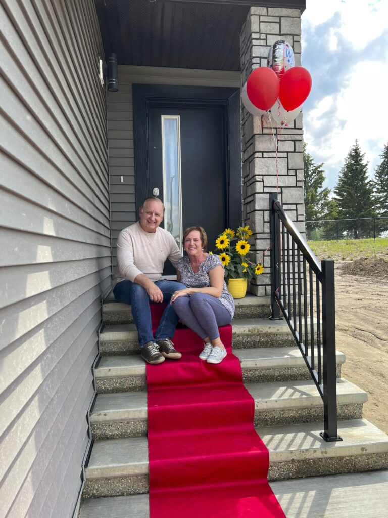 couple sitting on steps of new home